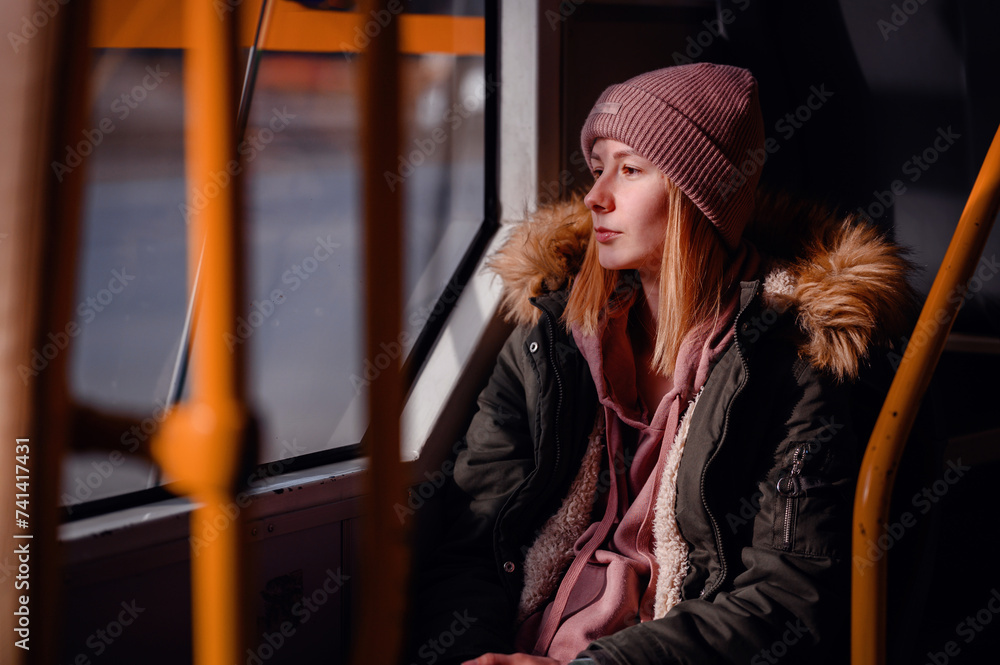 Young Woman Contemplating View on City Bus Ride, Casual Winter Attire Young Woman Contemplating View on City Bus Ride, Casual Winter Attire