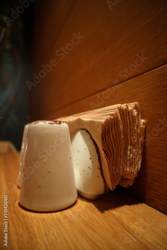 Obraz na płótnie There is a set of white saltshaker and tissue holder on a brown classy table great lightning w salonie