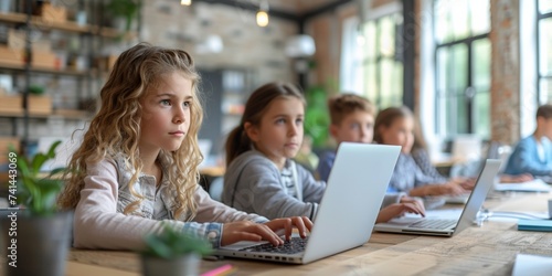 Classmates using laptops in a school classroom, studying together, showcasing technology in education.