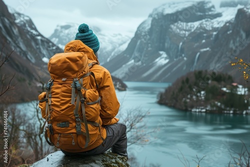 Person With Backpack Sitting on Rock