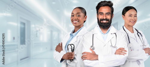 Three confident medical professionals with crossed arms, wearing white lab coats