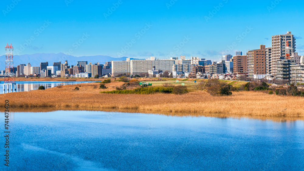Naklejka premium 青空広がる多摩川と東京の住宅街の風景【東京都・大田区】 The Tama River spreading out under the blue sky and the residential area of Tokyo - Japan