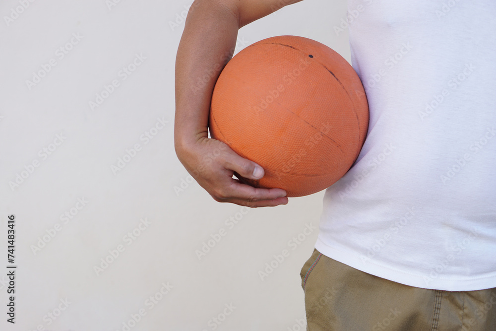 Close up man holds orange basketball. Concept, Sport equipment. Exercise for health. Healthy lifestyle.Work out makes strong of body. Close up man holds orange basketball. Concept, Sport equipment. Exercise for health. Healthy lifestyle.Work out makes strong of body.