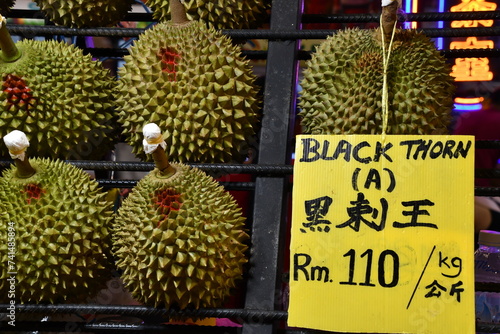 Delicious juicy fleshy aromatic Malaysian durians sold by fruit stalls in night market, Bukit Bintang, Kuala Lumpur, Malaysia. King of fruits in Southeast Asia with pungent smell but savoury taste. photo