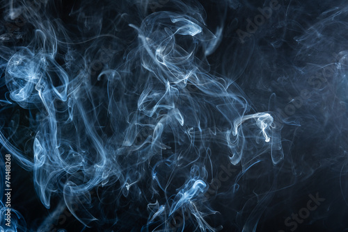 Smoke rising on a dark background, creating interesting shapes