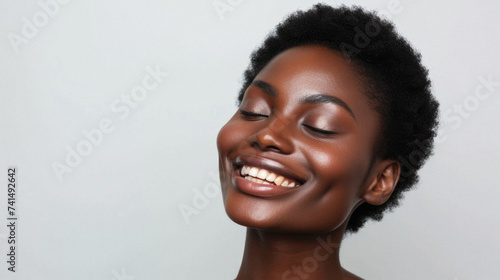 Happy attractive African American woman of middle age posing for beauty portrait. Pretty Black ethnic lady smiling on background, attractive female model advertising skin care treatment. Close up face