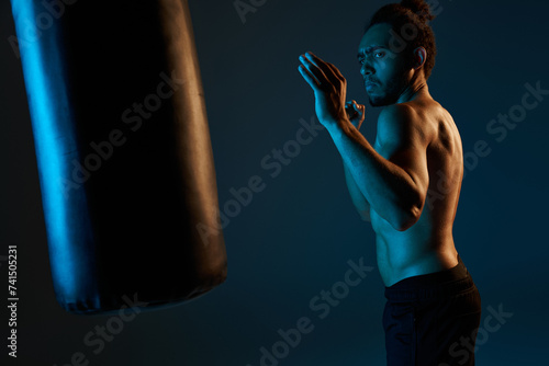 attractive young african american man topless in black shorts punching boxing pear while in gym © LIGHTFIELD STUDIOS