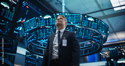 Stock Market Day Trader Working at an Exchange Office with Multi-Monitor Setup with Real Time Investment, Commodities and Foreign Funds Charts. Happy Businessman Celebrating a Successful Trade