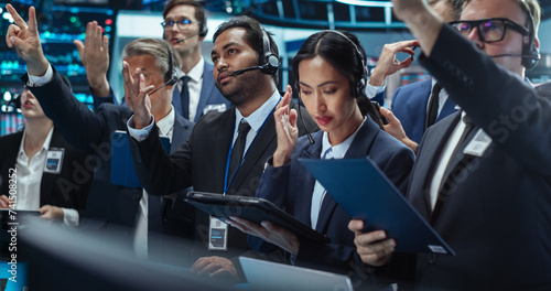 Portrait of Professional Traders Working on a Stock Exchange. Enthusiastic Men and Women Shouting, Signaling Orders for Company Shares and Commodities to Brokers at an Open Outcry Arbitrage photo