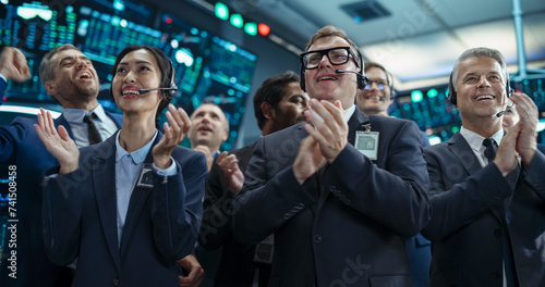 Group of Successful Stock Exchange Brokers Celebrating a Profitable Investment Bid on a Securities Market. Diverse Specialists and Asset Managers Clapping, Cheering, Giving High Fives to Team Members