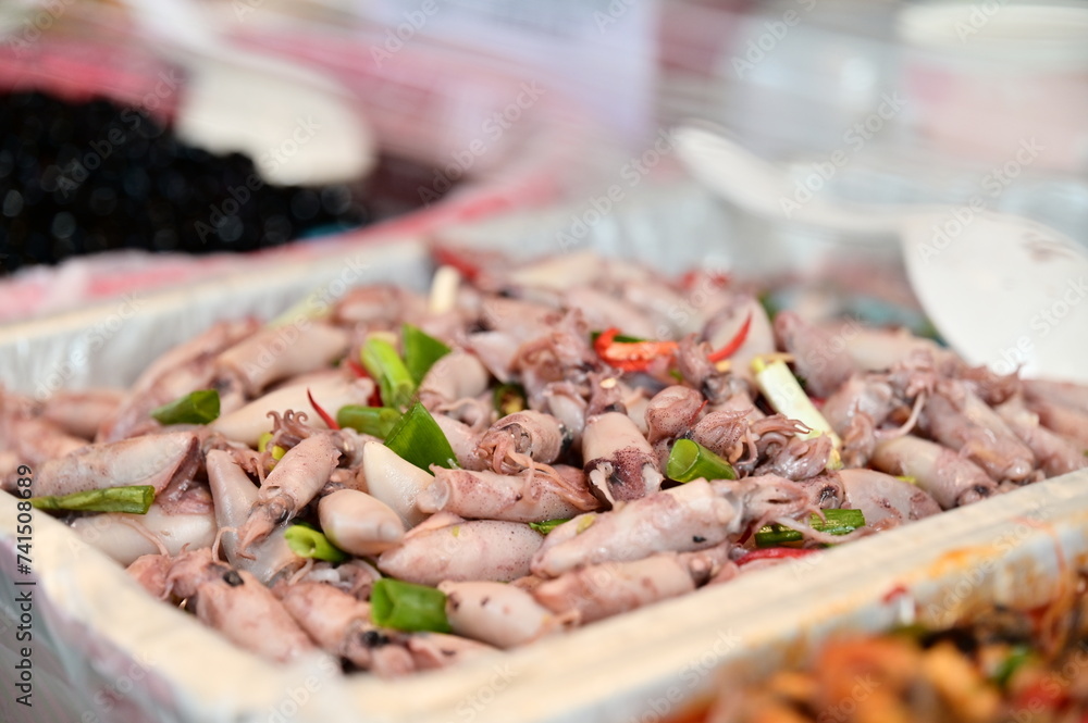Obraz premium You'll find a variety of ready-to-eat foods at the traditional market food stalls. One beloved option is the stir-fried squid depicted in the photo.