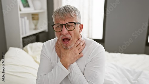 Pain-stricken middle age, grey-haired man writhing in agony, suffocating from a painful strangle in his pyjama, an alarming health problem surfaces in the gloom of his bedroom.