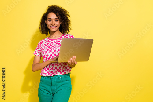 Portrait of gorgeous cheerful lady hold use wireless laptop empty space ad isolated on yellow color background