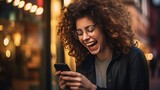 Young woman with contagious laughter looking at phone screen