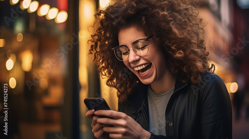 Young woman with contagious laughter looking at phone screen