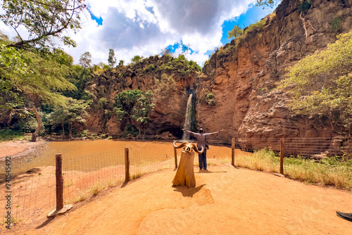 Rear view of a man against the background of a waterfall in Makalia Waterfal in Lake Nakuru National Park in Kenya