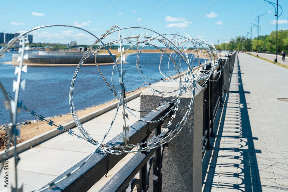Fototapeta premium Fence with barbed wire. No entry. The border is guarded
