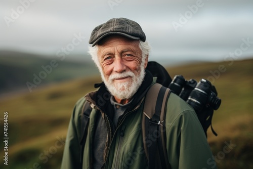 Portrait of senior man with a backpack and binoculars. © Nerea