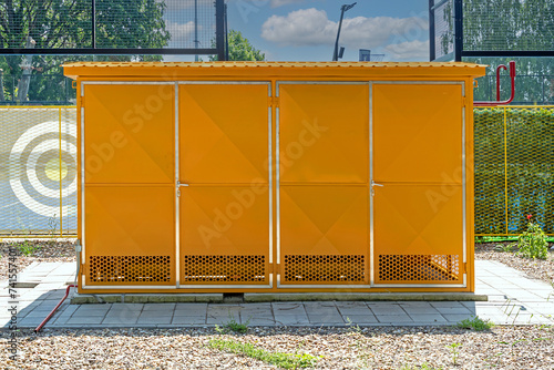 Yellow gas storage cabinet with ventilated sides outside on a field