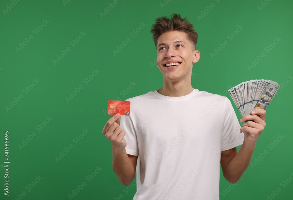 Happy man with credit card and dollar banknotes on green background. Space for text Happy man with credit card and dollar banknotes on green background. Space for text