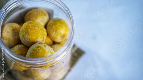 Nastar cookies are round in shape, with a shiny yellow top.inside it is filled with pineapple jam