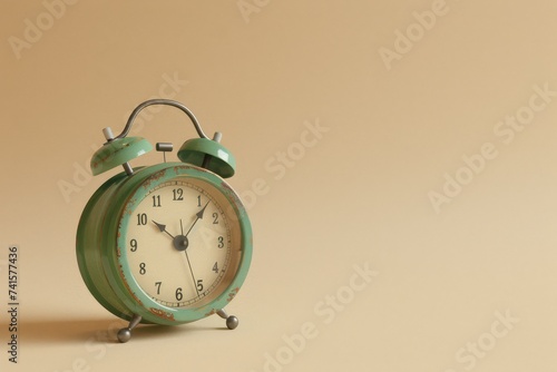 Vintage green alarm clock against a minimalist beige background.