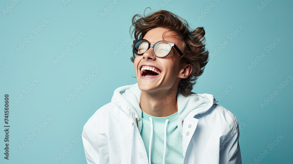 Happy Teenage Boy with Glasses and white Jacket isolated on b blue ackground Happy Teenage Boy with Glasses and white Jacket isolated on b blue ackground