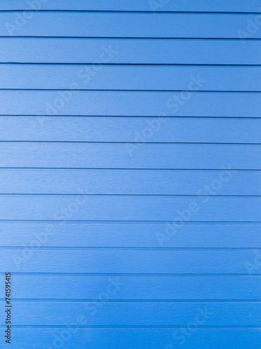 The blue siding plank on the house wall.