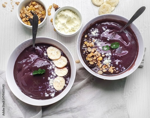  white bowl with iced açaí and granola typical Brazilian food and  wooden background photo