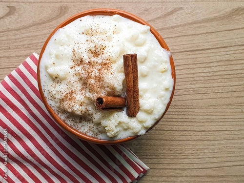 corn hominy, mungunzá typical Brazilian food in brown bowl with cinnamon and wooden background