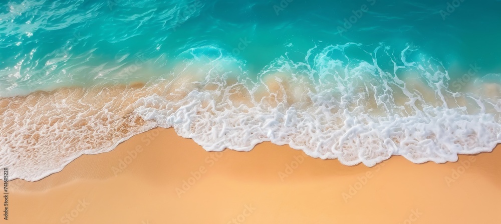 Fototapeta premium Aerial view of coastal beach with crashing waves, blue water, foam, and sandy shoreline in summer