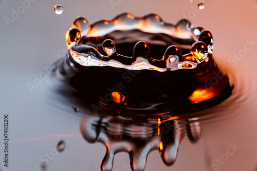 Golden Water Droplet Crown Splash with Warm Toned Background, Macro Side View photo