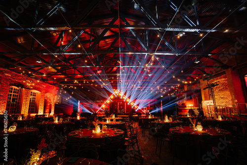 Foto Riga, Latvia - February 16, 2024 - an event space with a vibrant light show, red ambient lighting, and tables set for a festive occasion