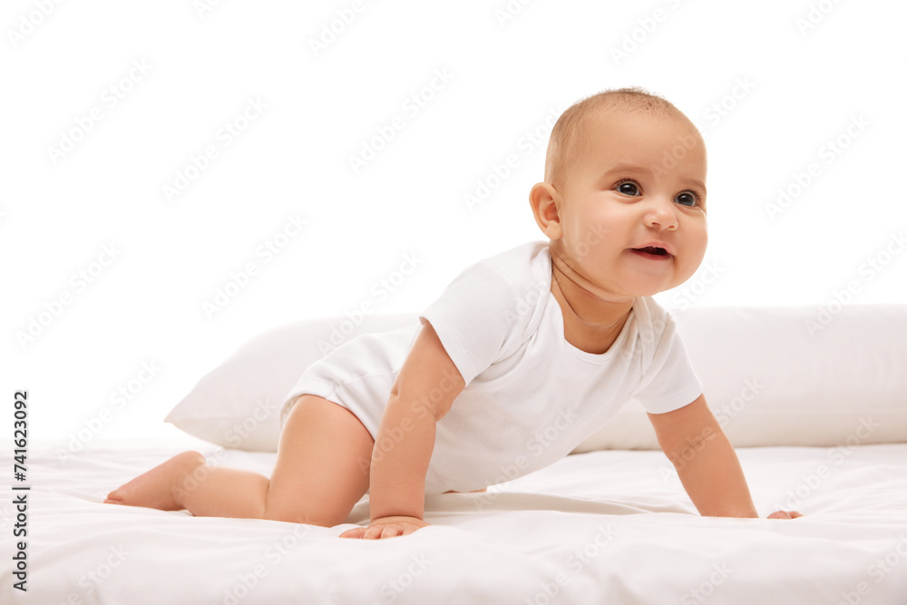 Adorable little baby girl, toddler in white clothes, crawling on bad with pillows against white background. Leisure, movements. Concept of childhood, family, care, motherhood, infancy, heath Adorable little baby girl, toddler in white clothes, crawling on bad with pillows against white background. Leisure, movements. Concept of childhood, family, care, motherhood, infancy, heath