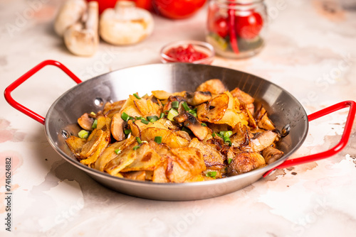 Pan-fried potatoes with mushrooms and onions in a frying pan