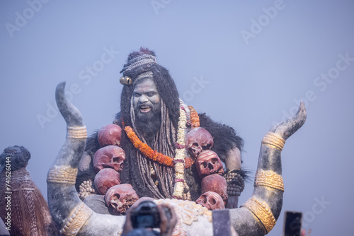 Masan Holi, Portrait of an male artist act as lord shiv with dry ash on face and body also in air while celebrating the holi festival as tradition at Harishchandra ghat in varanasi, India. photo