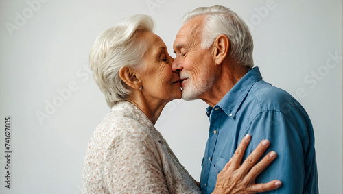 happy beautiful elder couple sharing a kiss on a clean white background