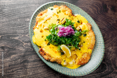 Fried big schnitzel from veal topside with cheese sauce photo