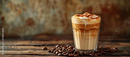 Caramel macchiato coffee milk and caramel drink in glass on wooden table with coffee beans sweet drink cafe food menu copy space for text. with copy space image. Place for adding text or design photo