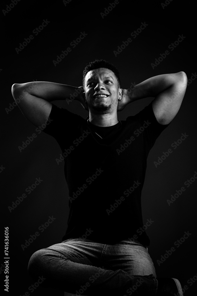 Portrait of young Brazilian man looking up smiling. black and white photography