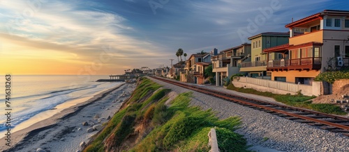 Houses at Del Mar Southern California along railroad on the beach at sunset Facade of upscale seaside homes overlooking the shore blue sky railway and sea. with copy space image
