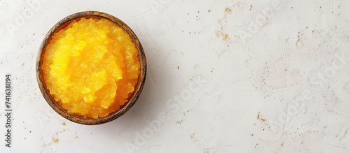 Yellow cosmetic mask scrub in a bowl top view. with copy space image. Place for adding text or design