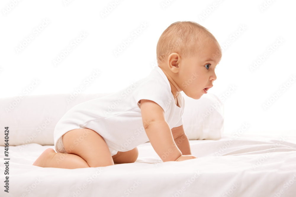Portrait of beautiful baby, little child, girl lying on bed, making awkward moves against white studio background. Concept of childhood, family, care, motherhood, infancy, heath