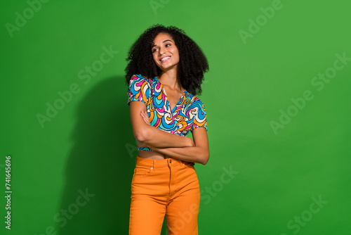 Photo of smiling american girlfriend waiting her boyfriend in cinema look empty space banner new movies isolated on green color background © deagreez