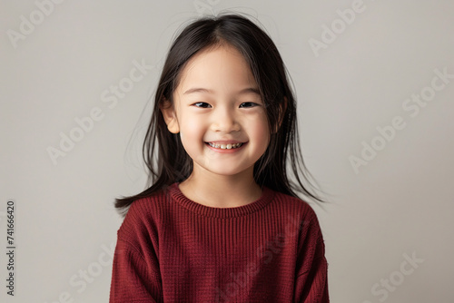 portrait of a child smiling with maroon color sweater for advertisement