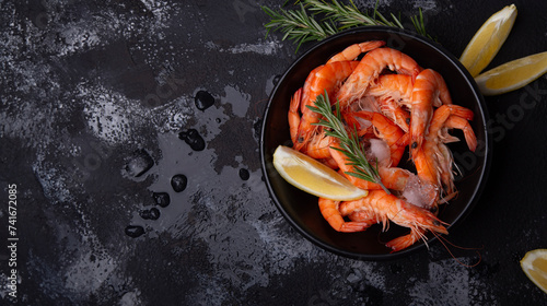 Bowl of fresh prawns on ice, garnished with lemon and rosemary on a dark, wet surface. Concept of seafood cuisine themes or culinary presentations
