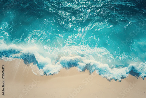 An overhead shot capturing the mesmerizing moment where frothy turquoise waves gracefully wash onto a sandy beach. © Oranuch