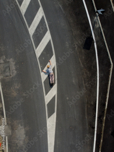Aerial view of a person laying down on the ground climbing road sign, Spinetta, Marengo, Piedmont, Italy. photo