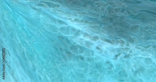 Bright glowing blue liquid energy flowing, moving, closeup. Azure ink in motion. Water texture in abstract art. Teal paint glow, flow in creative pattern. Clean turquoise in light ink background  photo