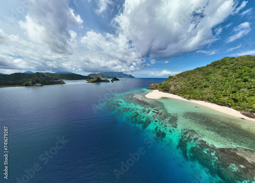 Aerial View of pristine beach and healthy coral reef on Mahoro Island next to Siau on a partly cloudy sunny day in Sitaro, Indonesia. photo